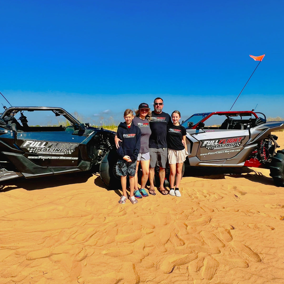 outside photo of Fullflight Racing owners and children standing by UTVs